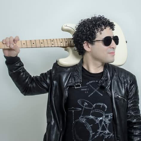 Studio portrait Everton Vidal Azevedo posing with a fender white electric guitar on his shoulder, photo by Marvin Montes.