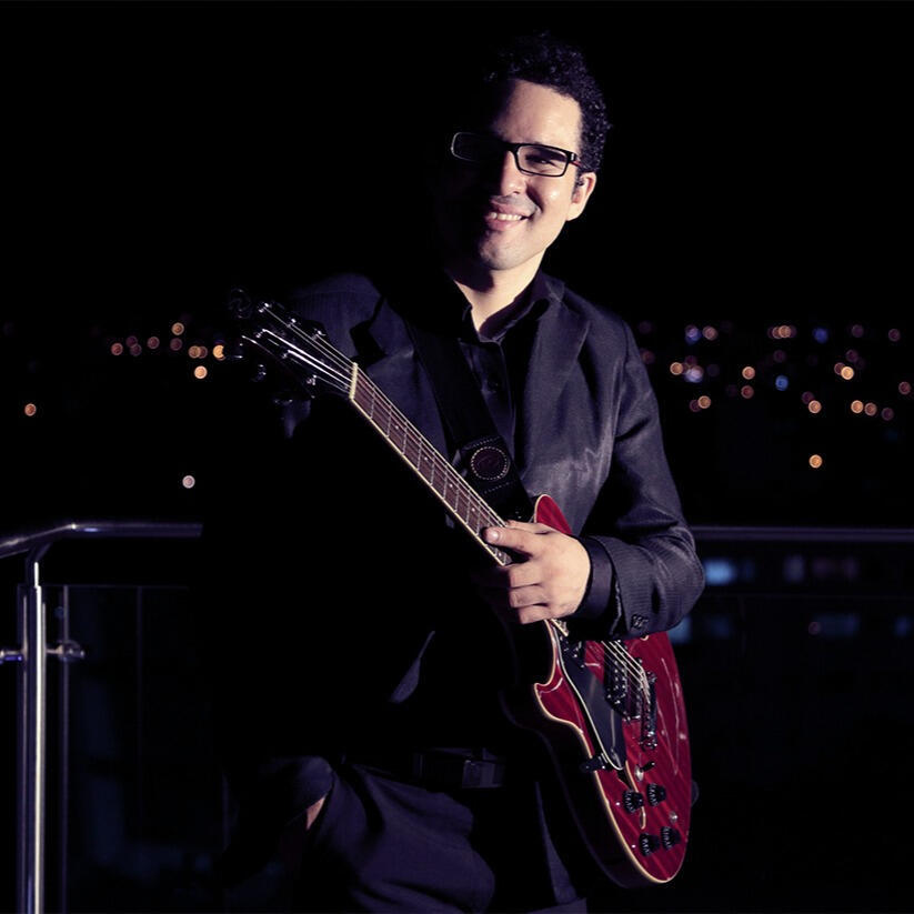 Everton Vidal Azevedo playing guitar at night on a rooftop (Hotel Cortez) in Santa Cruz de la Sierra, photo by Claudio Arduz.