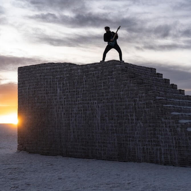 Everton Vidal Azevedo standing with guitar on the Sky Staircase at the Salar de Uyuni, photo by Marvin Montes.