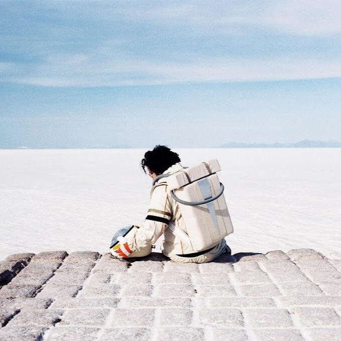 Everton Vidal Azevedo in an astronaut suit sitting on the salt blocks at the Salar de Uyuni. Photo by Marvin Montes.