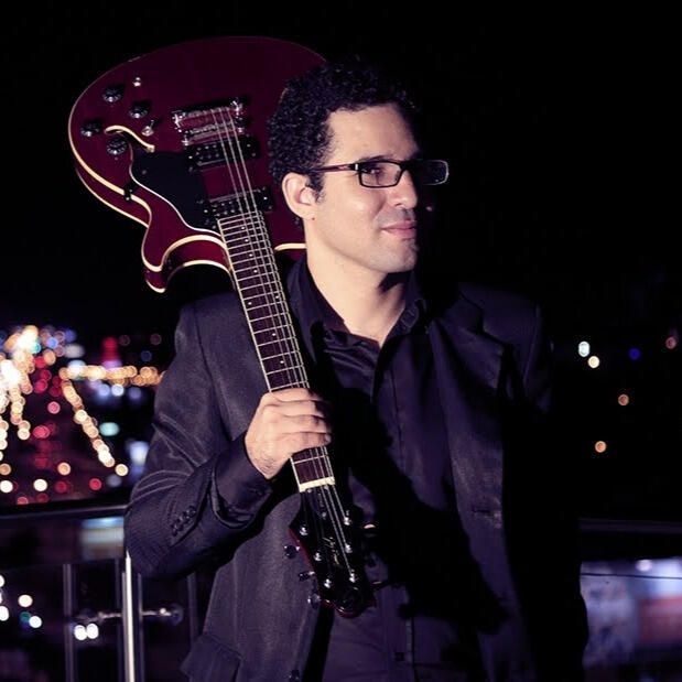 City lights in Santa Cruz (by Claudio Arduz) Everton Vidal Azevedo portrait with a red semiacoustic electric guitar on a rooftop (Hotel Cortez) in Santa Cruz de la Sierra, photo by Claudio Arduz.