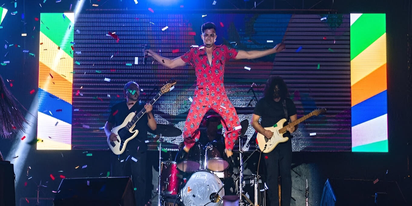 Everton Vidal performing with singer Luis Gamarra on the main stage of Expocruz, surrounded by confetti and dynamic lighting.
