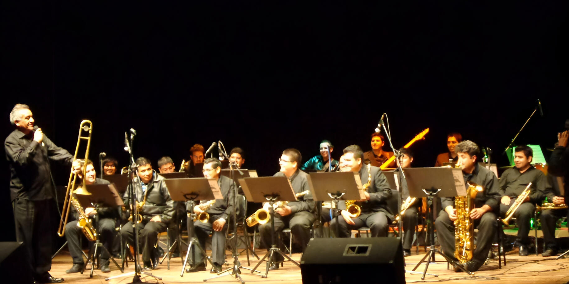 Live performance with the Cruceña Big Band Everton Vidal Azevedo performing as a guitarist with a large symphonic jazz ensemble during a live concert (Cruceña Big Band).