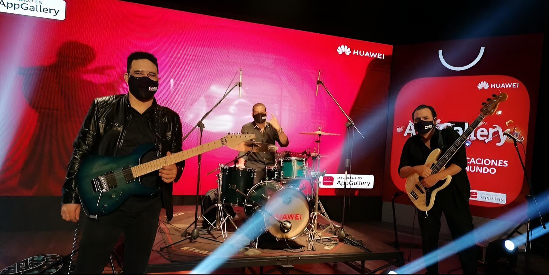 Everton Vidal performing live with The Funky Tones during a special concert for Huawei Bolivia, playing electric guitar on a stage with bright red LED screens and masked band members.